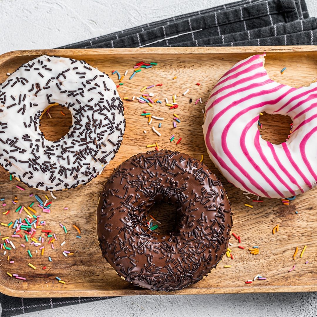 Donuts with chocolate, pink glazed and sprinkles Doughnut. White background. Top view.